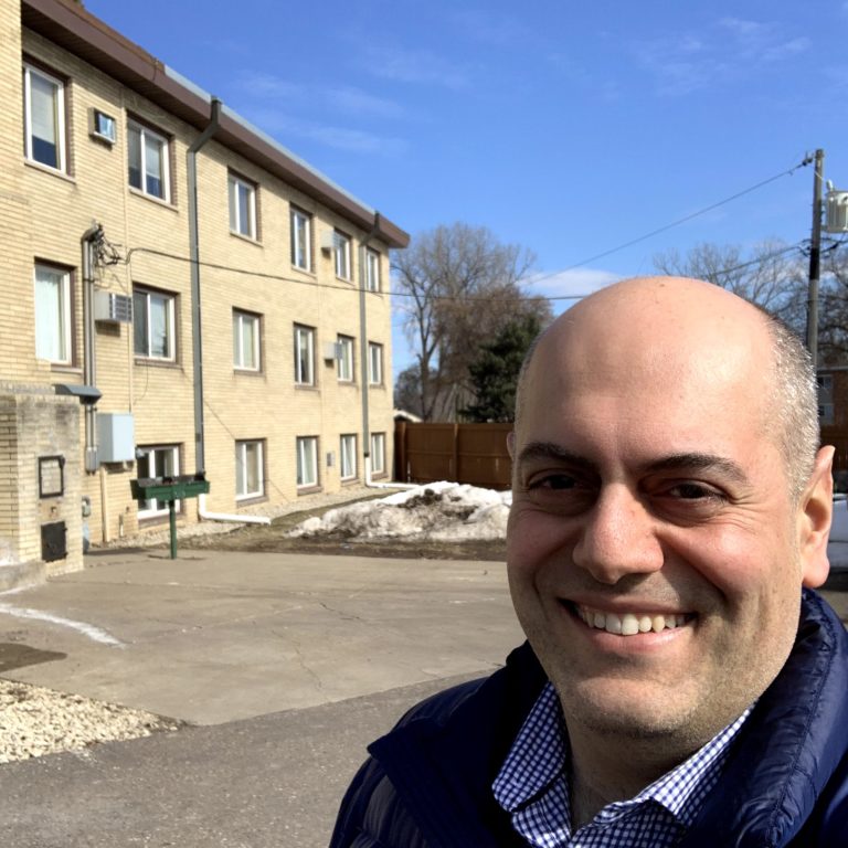 Davit Gharibyan standing in front of second multifamily property in North Saint Paul